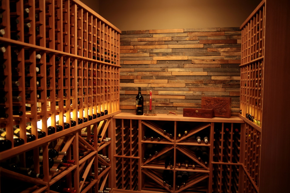 Mid-sized traditional wine cellar in Vancouver with storage racks, medium hardwood floors and brown floor.