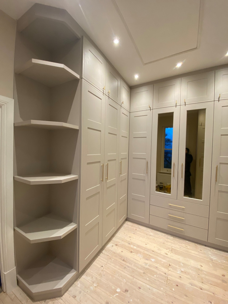 Large victorian built-in wardrobe in Other with shaker cabinets, beige cabinets, medium hardwood flooring, yellow floors and feature lighting.