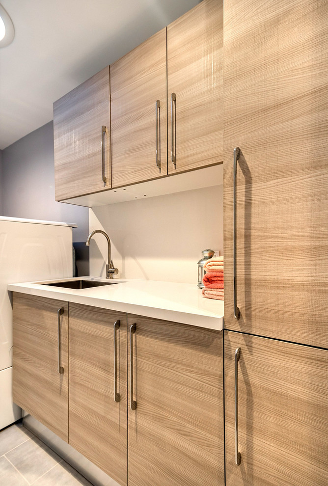 Inspiration for a mid-sized contemporary single-wall dedicated laundry room in San Francisco with a drop-in sink, flat-panel cabinets, light wood cabinets, quartz benchtops, grey walls and a side-by-side washer and dryer.