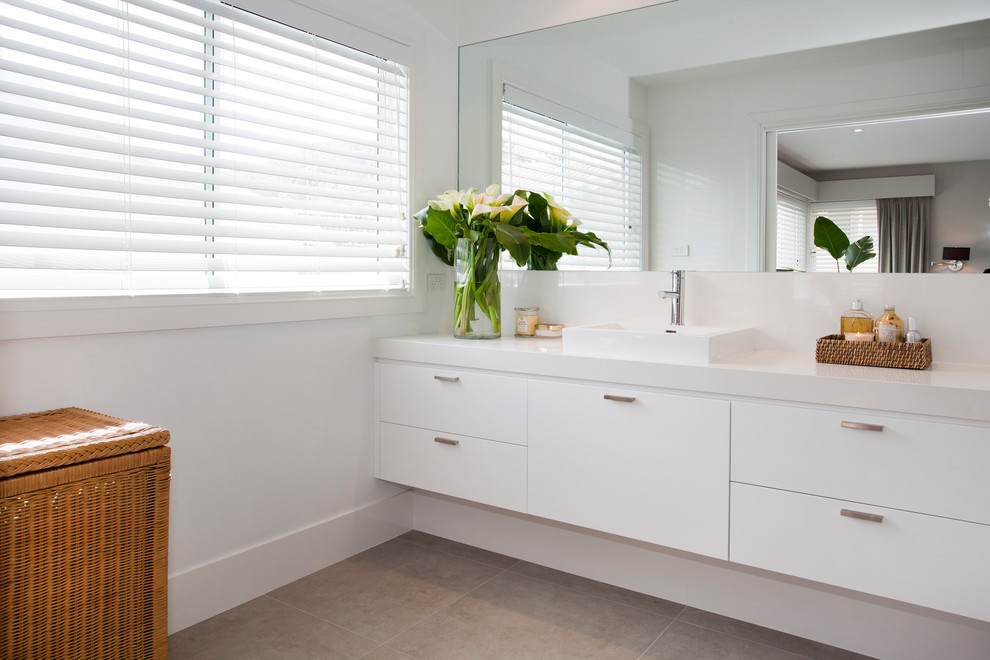Beach style 3/4 bathroom in Sydney with a vessel sink, flat-panel cabinets, white cabinets, engineered quartz benchtops, gray tile, ceramic tile, white walls and ceramic floors.