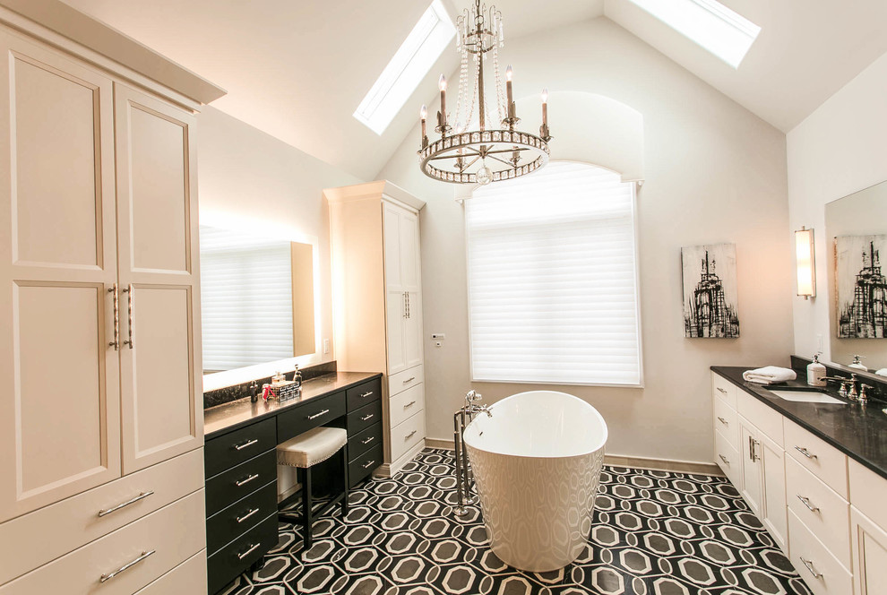 Inspiration for a large transitional master ceramic tile and multicolored floor freestanding bathtub remodel with raised-panel cabinets, white cabinets, white walls, an undermount sink, quartz countertops and black countertops