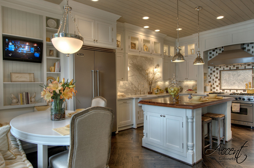 Design ideas for an expansive traditional u-shaped eat-in kitchen in Houston with a farmhouse sink, shaker cabinets, white cabinets, granite benchtops, multi-coloured splashback, stone slab splashback, stainless steel appliances, dark hardwood floors and with island.