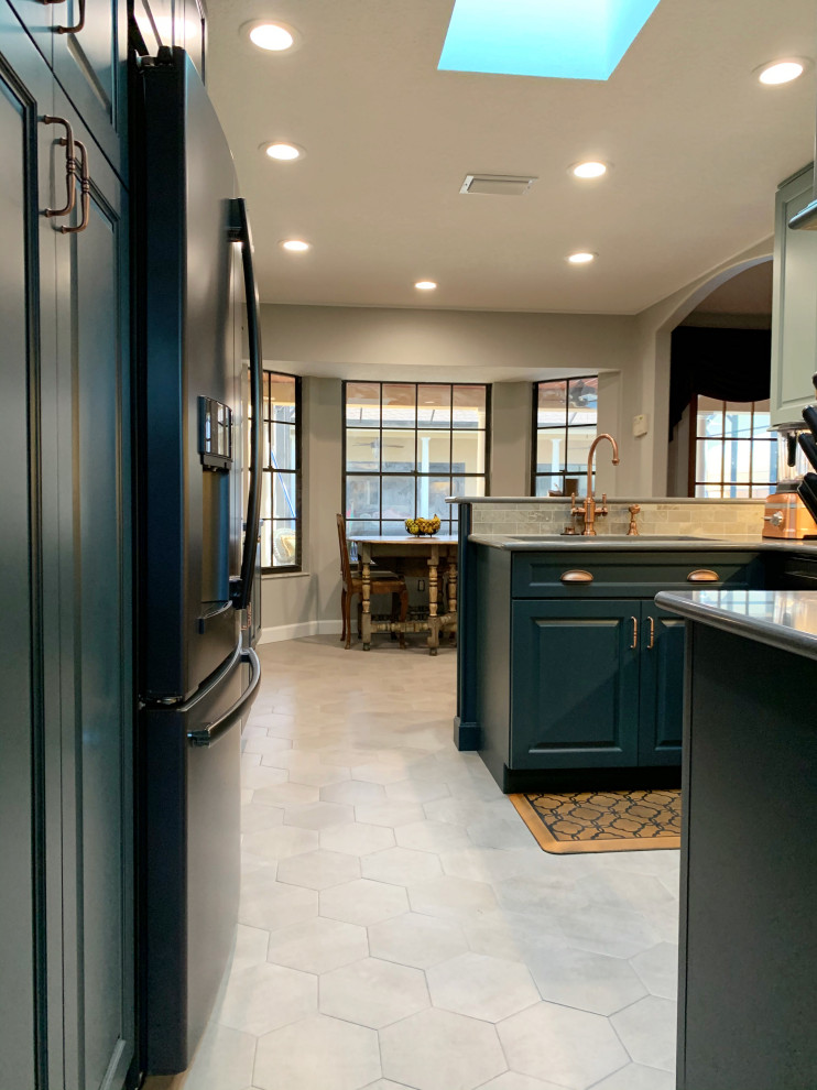 Inspiration for a mid-sized u-shaped eat-in kitchen in Orlando with an undermount sink, raised-panel cabinets, blue cabinets, quartz benchtops, brown splashback, brick splashback, black appliances, ceramic floors, a peninsula, grey floor, grey benchtop and recessed.