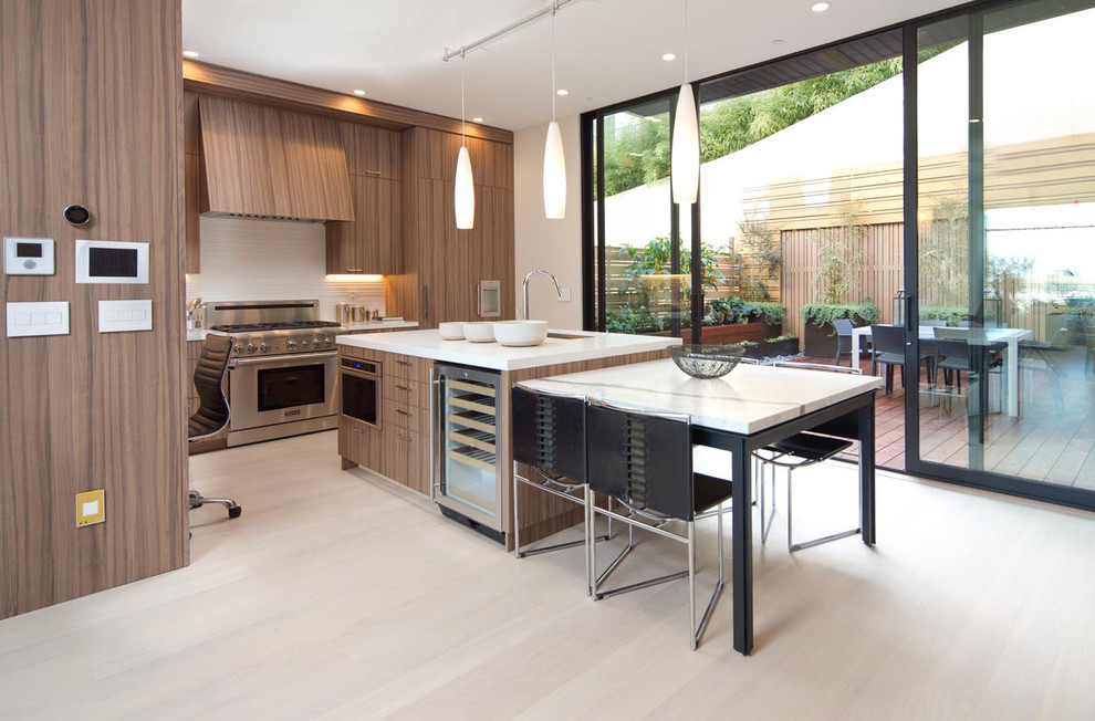 Mid-sized contemporary l-shaped eat-in kitchen in San Francisco with an undermount sink, flat-panel cabinets, medium wood cabinets, white splashback, panelled appliances, light hardwood floors and with island.