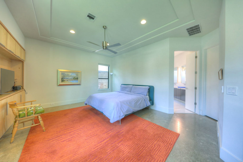 Large midcentury master bedroom in Houston with white walls, concrete floors, no fireplace and grey floor.