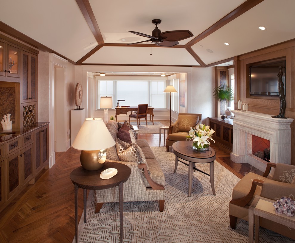 Mid-sized tropical family room in Philadelphia with beige walls, a standard fireplace, a stone fireplace surround, a wall-mounted tv, a home bar and medium hardwood floors.