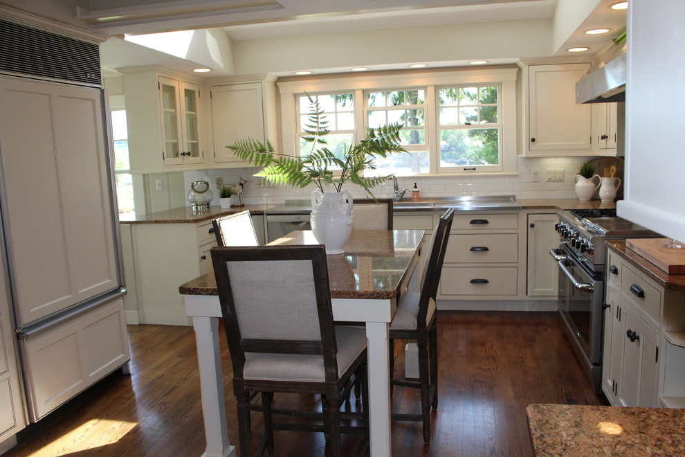 Inspiration for a mid-sized transitional u-shaped dark wood floor eat-in kitchen remodel in Boston with an undermount sink, recessed-panel cabinets, white cabinets, granite countertops, white backsplash, ceramic backsplash, stainless steel appliances and an island