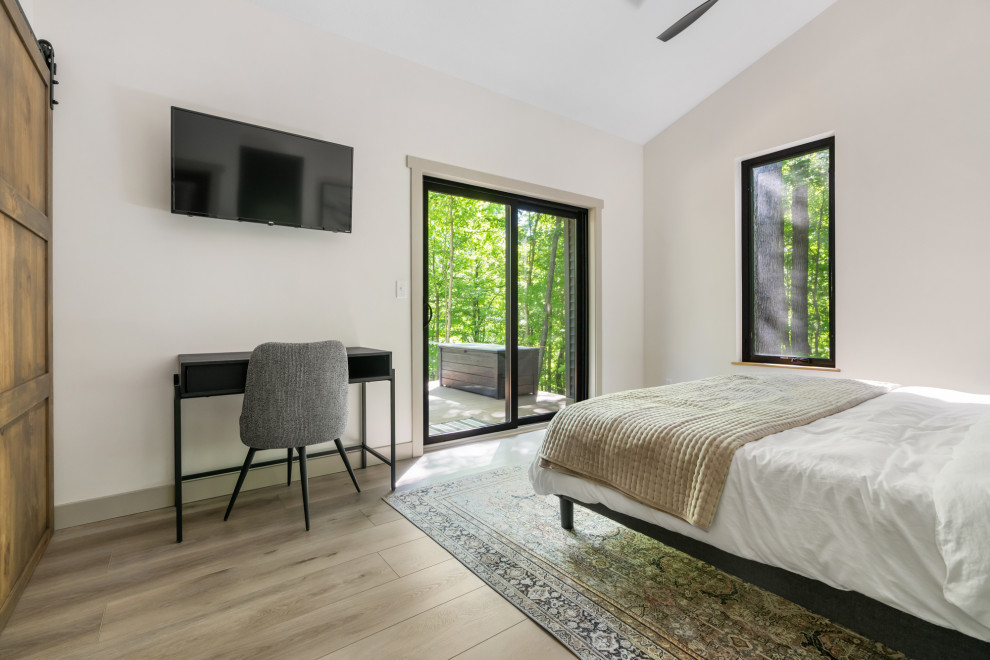 На фото: хозяйская спальня среднего размера в современном стиле с белыми стенами, полом из винила, коричневым полом и сводчатым потолком