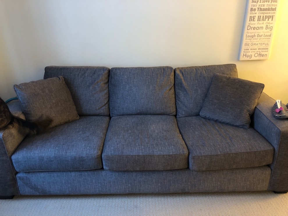 Neutral tan sofa with blue-grey and celery green throw pillows