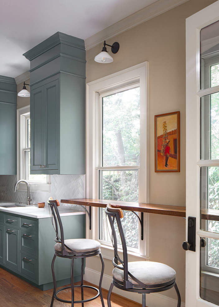 Inspiration for a large transitional galley eat-in kitchen in Atlanta with an undermount sink, recessed-panel cabinets, blue cabinets, quartz benchtops, grey splashback, ceramic splashback, stainless steel appliances, light hardwood floors, no island, brown floor and multi-coloured benchtop.