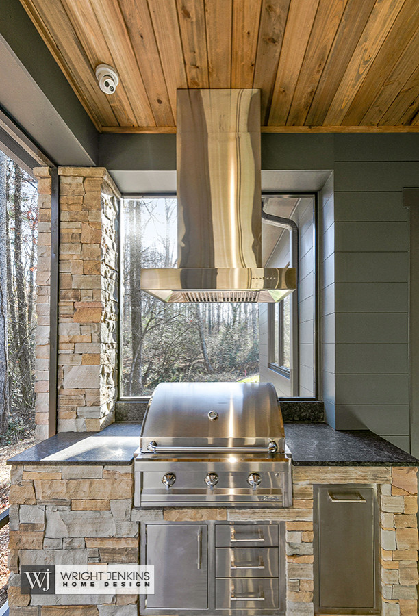 Inspiration pour une terrasse arrière craftsman de taille moyenne avec une cuisine d'été, du carrelage et une extension de toiture.