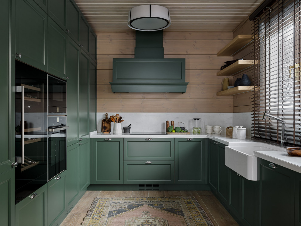 Design ideas for a medium sized rustic u-shaped enclosed kitchen in Moscow with green cabinets, white splashback, stone slab splashback, stainless steel appliances, porcelain flooring, white worktops, a wood ceiling, a belfast sink, recessed-panel cabinets and brown floors.