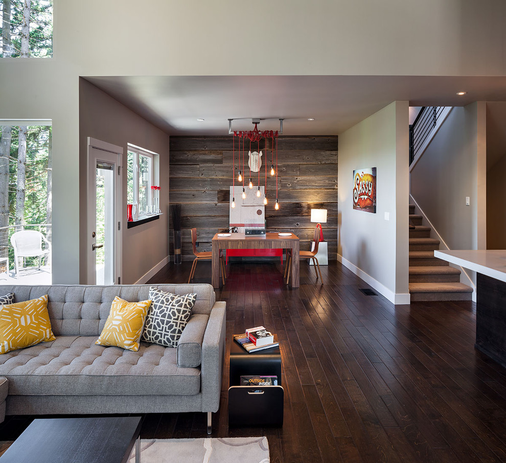 This is an example of a large contemporary open concept family room in Portland with grey walls, dark hardwood floors and brown floor.