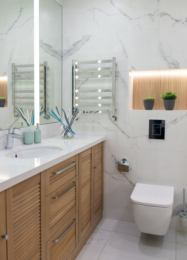 Inspiration for a small contemporary bathroom in Other with louvered cabinets, medium wood cabinets, a wall-mount toilet, gray tile, porcelain tile, an undermount sink, grey floor, white benchtops, a single vanity and a built-in vanity.