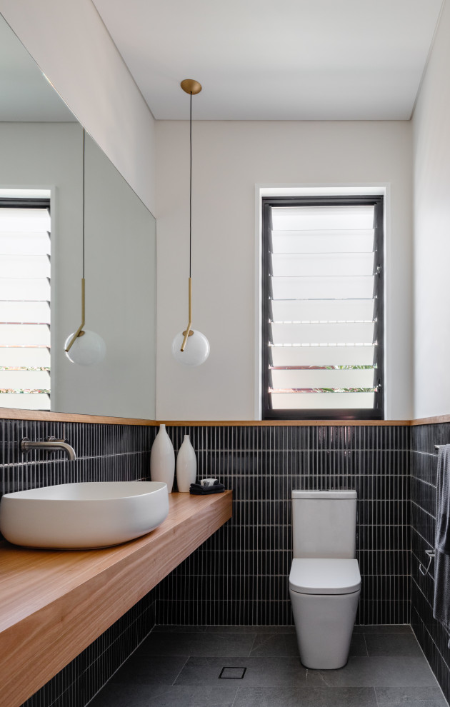 Foto de cuarto de baño actual con baldosas y/o azulejos azules, baldosas y/o azulejos de cerámica, lavabo tipo consola y encimera de madera