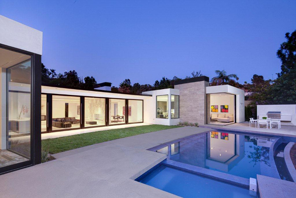 Mid-sized modern backyard rectangular infinity pool in Los Angeles with concrete slab.