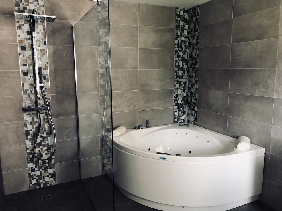 Large contemporary master bathroom in Paris with a hot tub, a curbless shower, brown tile, gray tile, ceramic tile, ceramic floors, grey floor, an open shower, flat-panel cabinets, white cabinets, a two-piece toilet, grey walls, a wall-mount sink, glass benchtops and grey benchtops.