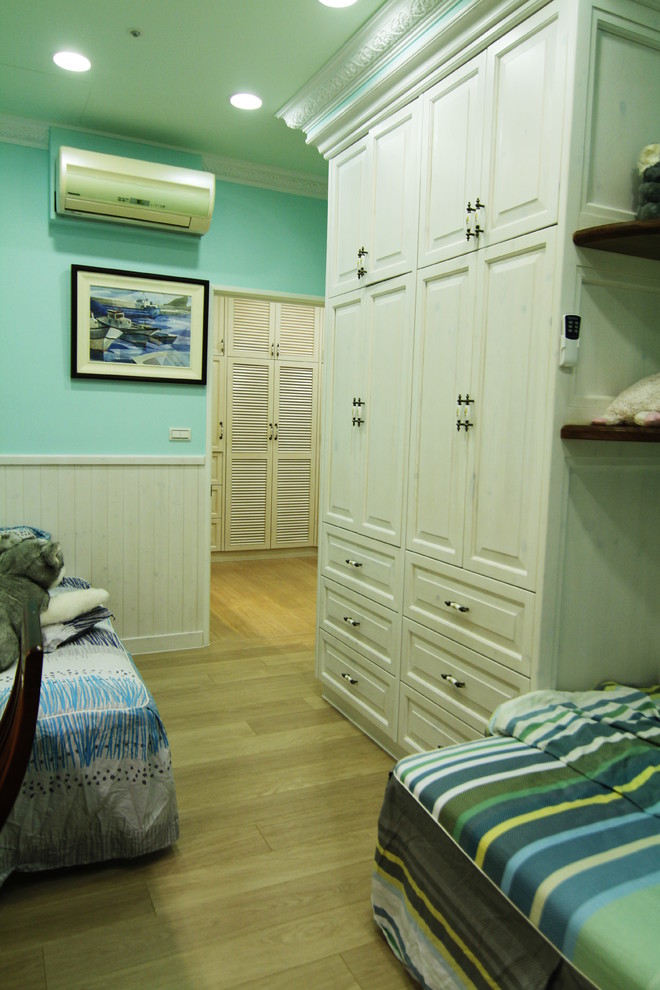 Photo of a small country gender-neutral kids' room in Other with green walls, laminate floors and yellow floor.