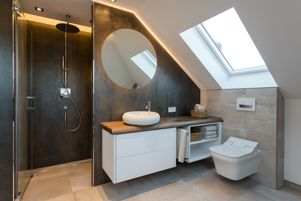 Design ideas for a small contemporary bathroom in Dresden with flat-panel cabinets, white cabinets, an alcove shower, a wall-mount toilet, beige tile, brown tile, white walls, a vessel sink, wood benchtops, beige floor, a hinged shower door, cement tile, cement tiles and brown benchtops.