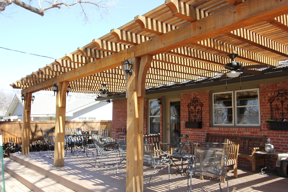 This is an example of a mid-sized traditional backyard deck in Other with a pergola.