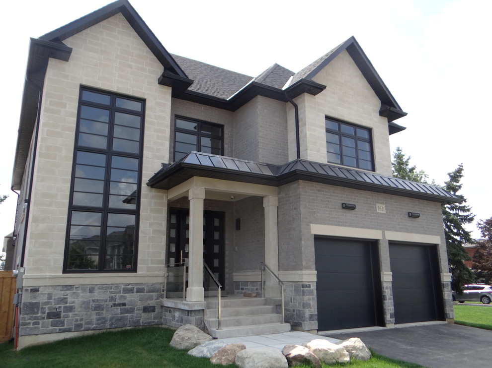 Photo of a large transitional two-storey beige house exterior in Toronto with stone veneer.