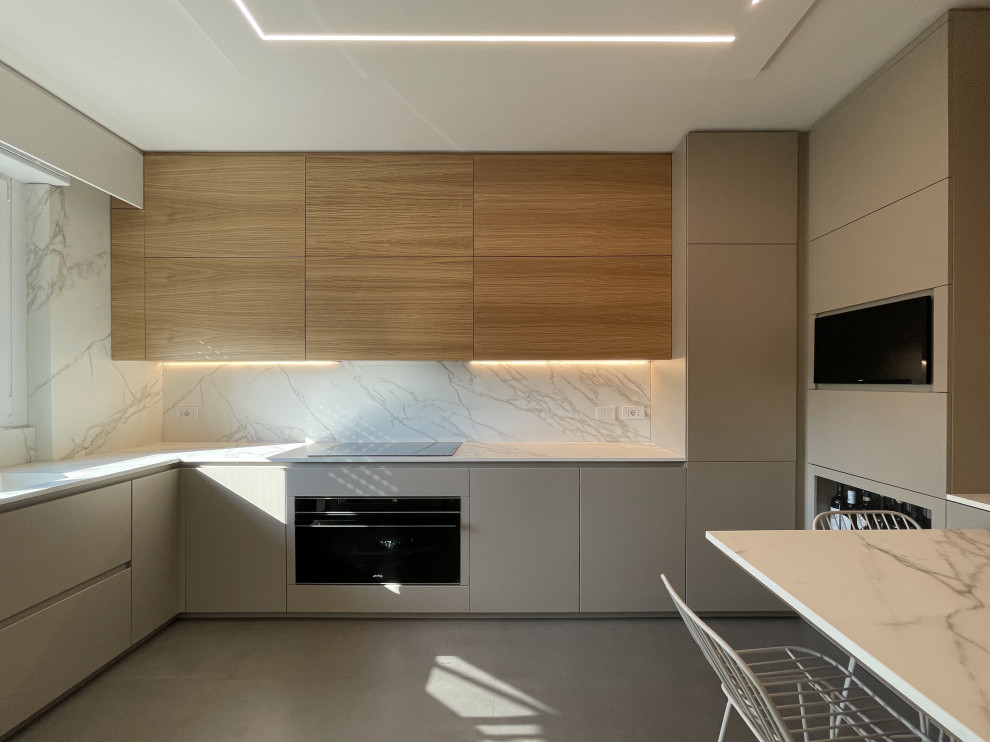 Immagine di una cucina minimalista di medie dimensioni con lavello da incasso, ante lisce, ante grigie, top in marmo, paraspruzzi bianco, paraspruzzi in marmo, elettrodomestici neri, pavimento in gres porcellanato, pavimento grigio e top bianco