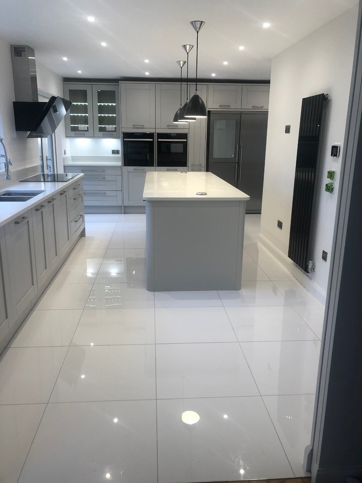 Photo of a large modern open plan kitchen in Glasgow with a drop-in sink, shaker cabinets, grey cabinets, coloured appliances, porcelain floors, with island and white floor.