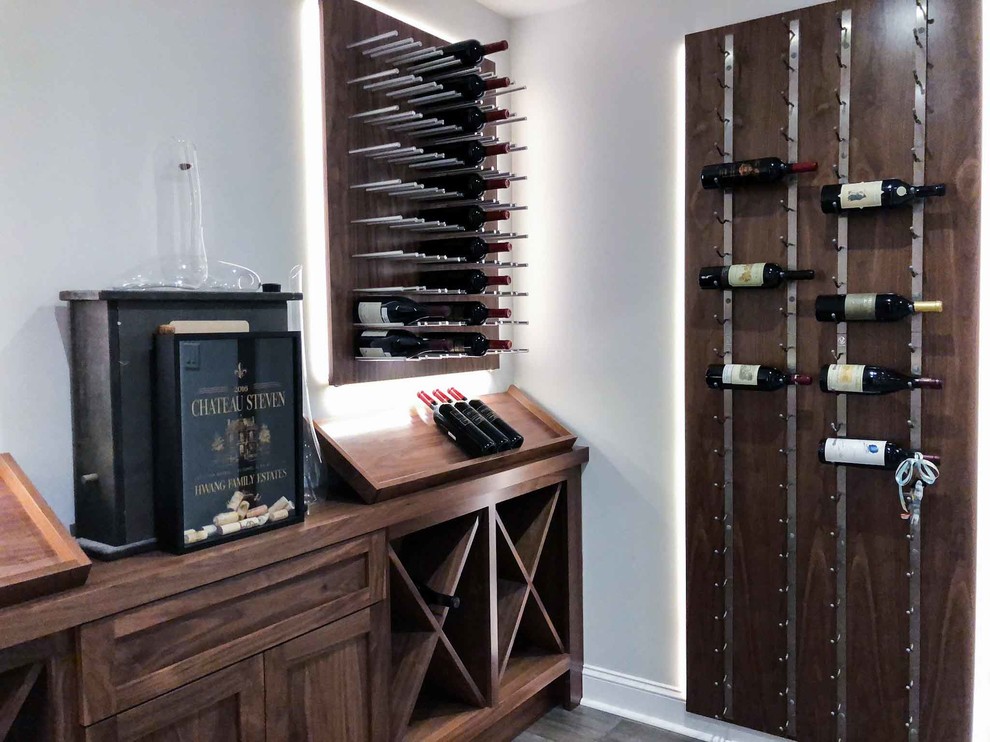 Photo of a mid-sized transitional wine cellar in Philadelphia with laminate floors, display racks and grey floor.