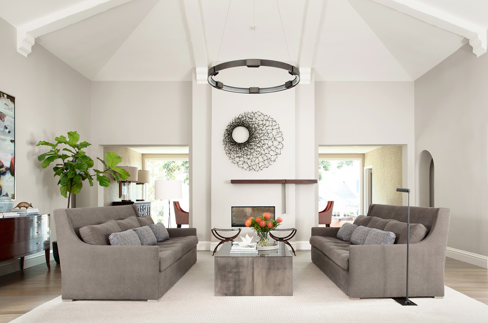Inspiration for an expansive contemporary formal enclosed living room in San Francisco with grey walls, a two-sided fireplace, a plaster fireplace surround and medium hardwood floors.