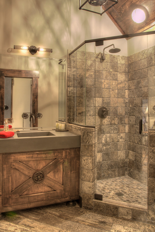 Inspiration for a mid-sized country master bathroom in Minneapolis with raised-panel cabinets, dark wood cabinets, a freestanding tub, a corner shower, gray tile, travertine, beige walls, ceramic floors, an integrated sink, concrete benchtops, beige floor, an open shower and grey benchtops.