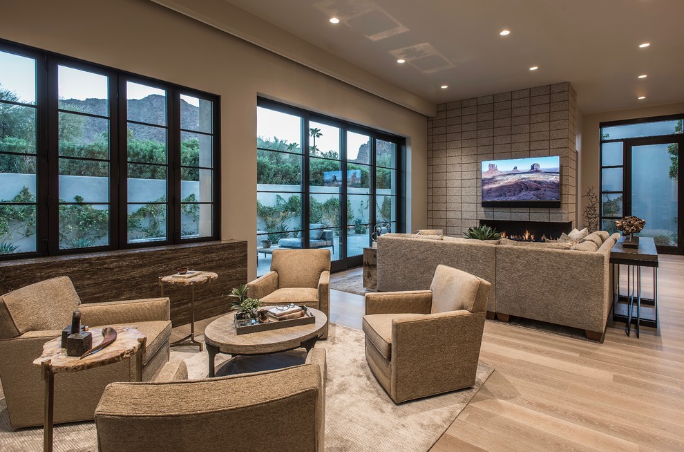 Expansive contemporary open concept living room in Phoenix with beige walls, medium hardwood floors, a two-sided fireplace, a brick fireplace surround, a wall-mounted tv and beige floor.