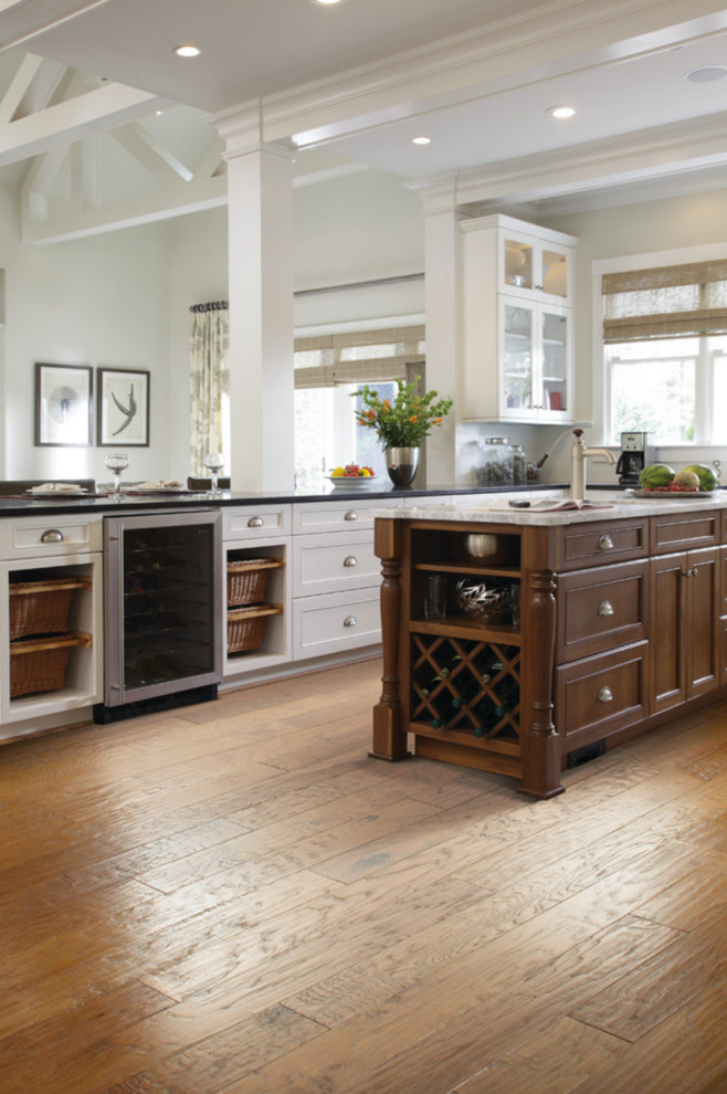 Inspiration for a large transitional u-shaped medium tone wood floor and brown floor open concept kitchen remodel with an undermount sink, shaker cabinets, white cabinets, solid surface countertops, white backsplash, stainless steel appliances and an island