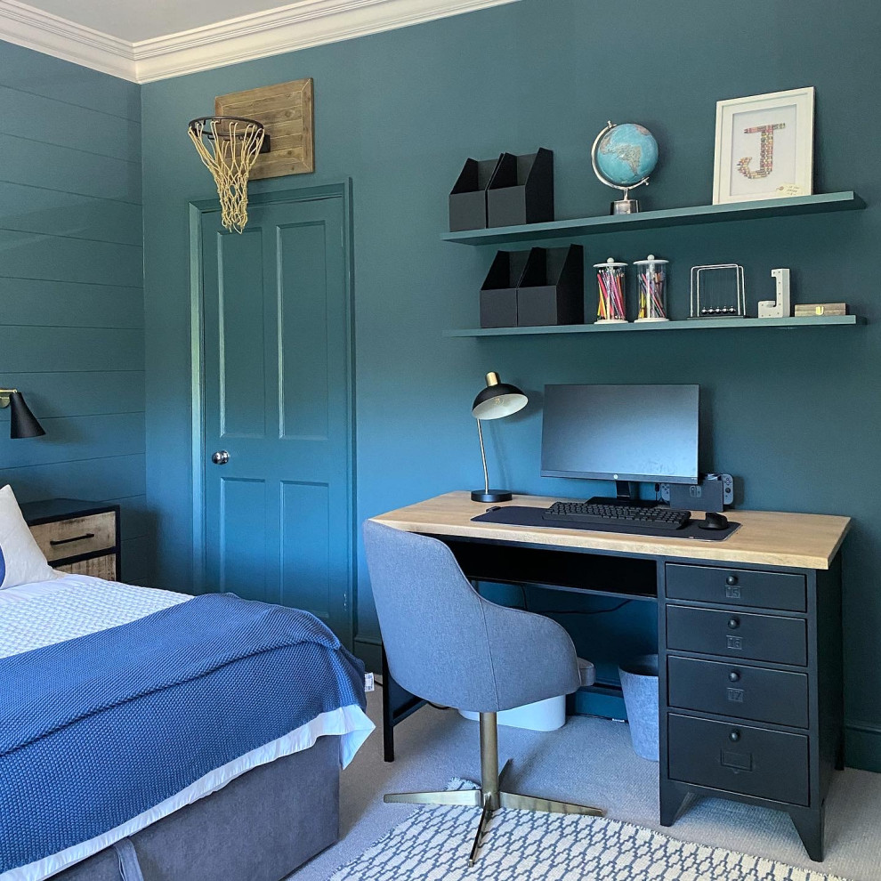 Photo of an industrial bedroom in Surrey with blue walls, carpet, beige floor and planked wall panelling.