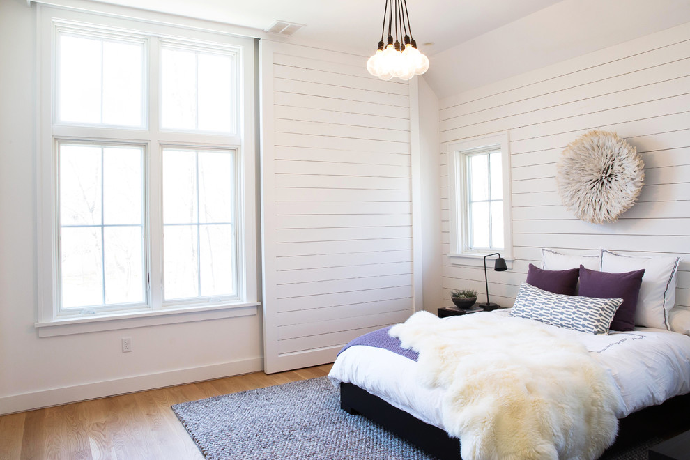 Design ideas for a beach style master bedroom in Boston with white walls and light hardwood floors.