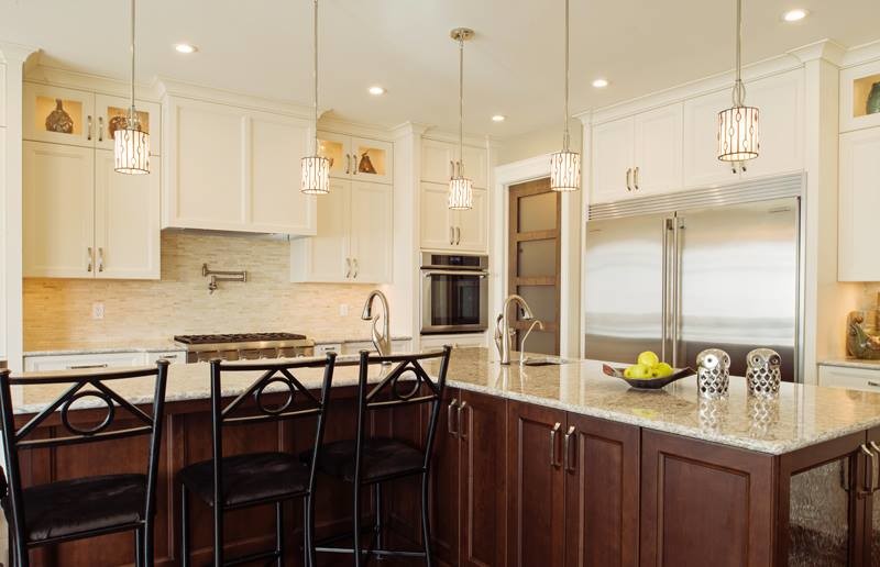 Example of a transitional l-shaped eat-in kitchen design in Calgary with an undermount sink, glass-front cabinets, white cabinets, soapstone countertops, beige backsplash, stone tile backsplash and stainless steel appliances