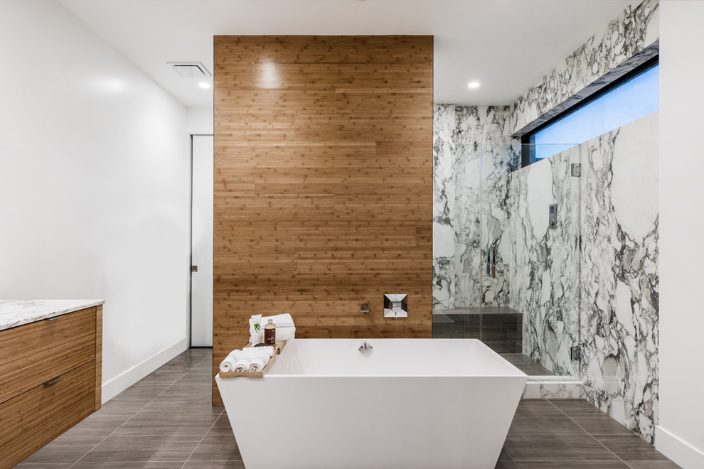 Design ideas for a large contemporary master bathroom in Las Vegas with flat-panel cabinets, light wood cabinets, a freestanding tub, multi-coloured tile, white walls, brown floor, a hinged shower door, multi-coloured benchtops and a shower seat.