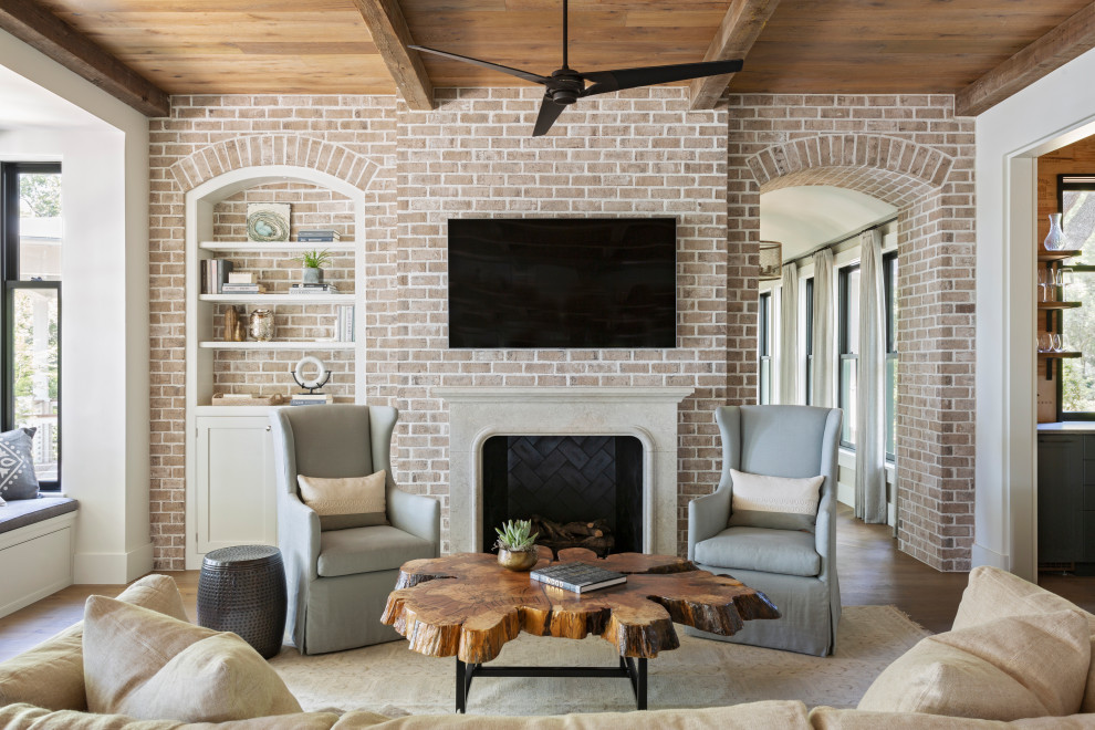 Beach style family room in Charleston with limestone floors, a standard fireplace, a plaster fireplace surround and a wall-mounted tv.