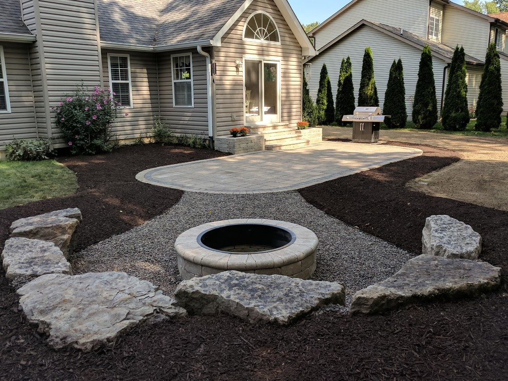 Photo of a large transitional backyard patio in Chicago with a fire feature, natural stone pavers and no cover.