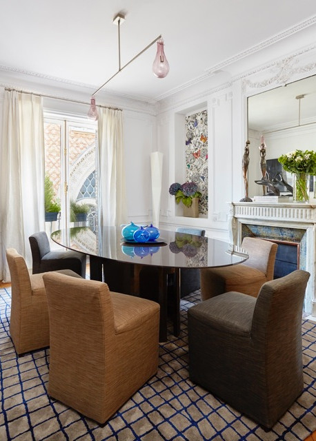 Cette image montre une salle à manger design fermée et de taille moyenne avec un mur blanc, moquette, une cheminée standard, un manteau de cheminée en pierre et un sol multicolore.