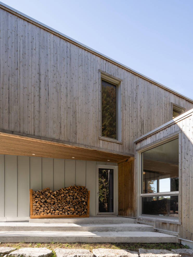 Réalisation d'une façade de maison design en bois avec un toit plat.