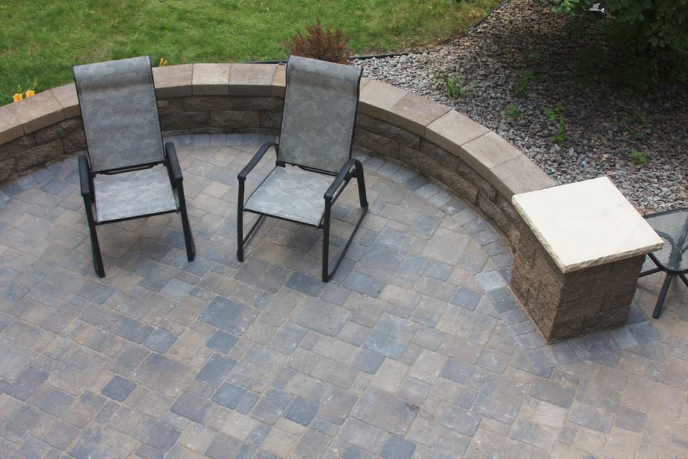 Photo of a mid-sized traditional backyard patio in Minneapolis with a fire feature, concrete pavers and no cover.
