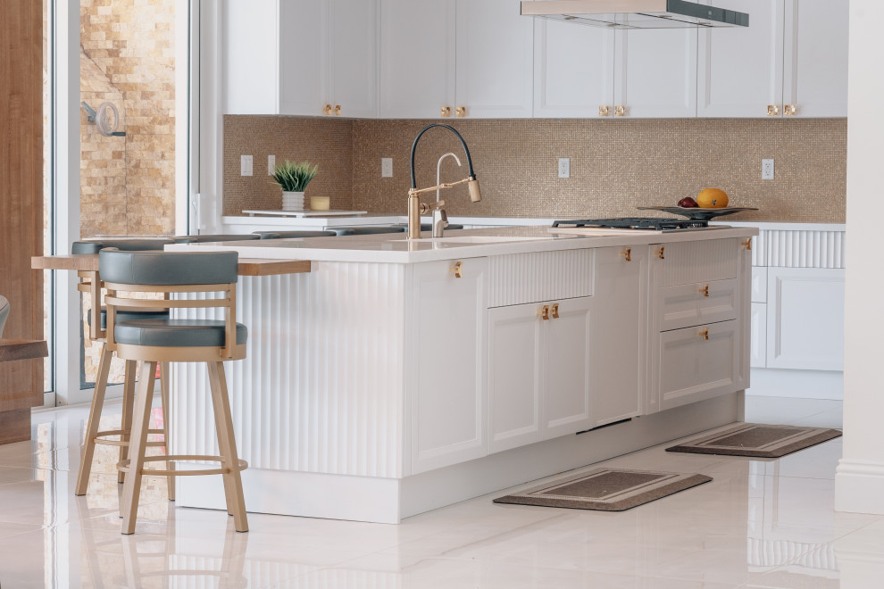 This is an example of a large transitional u-shaped separate kitchen in Miami with an integrated sink, shaker cabinets, brown cabinets, marble benchtops, yellow splashback, mosaic tile splashback, stainless steel appliances, marble floors, with island, beige floor and white benchtop.