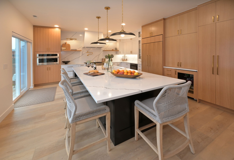 Open concept kitchen - large transitional l-shaped laminate floor and beige floor open concept kitchen idea in Seattle with shaker cabinets, white cabinets, quartz countertops, white backsplash, quartz backsplash, stainless steel appliances, an island and white countertops