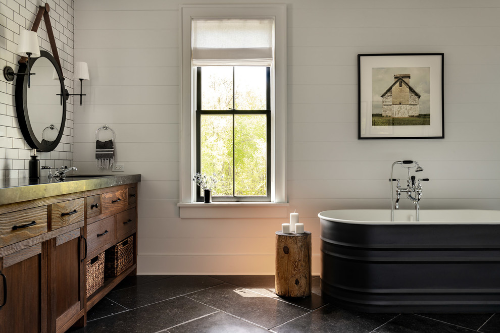 Design ideas for a large country master bathroom in New York with flat-panel cabinets, brown cabinets, a freestanding tub, white tile, white walls, an undermount sink, concrete benchtops, black floor, black benchtops and slate floors.