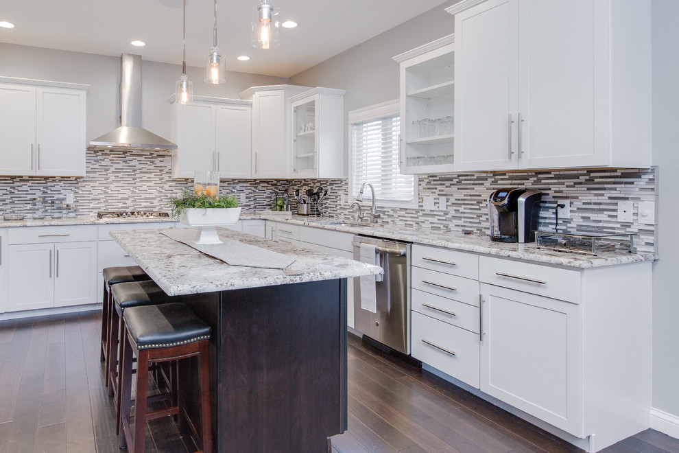 Design ideas for a large transitional open plan kitchen in Grand Rapids with an undermount sink, shaker cabinets, granite benchtops, multi-coloured splashback, mosaic tile splashback, stainless steel appliances, dark hardwood floors, with island and brown floor.