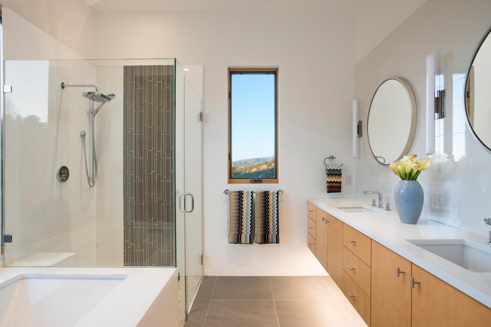 Inspiration for a mid-sized modern master bathroom in Albuquerque with flat-panel cabinets, an undermount tub, white tile, glass tile, white walls, porcelain floors, an undermount sink, engineered quartz benchtops, grey floor, a hinged shower door, medium wood cabinets and a corner shower.