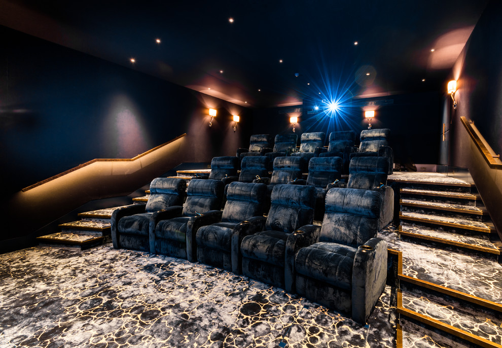 This is an example of a large contemporary enclosed home theatre in London with blue walls, carpet, a projector screen and blue floor.