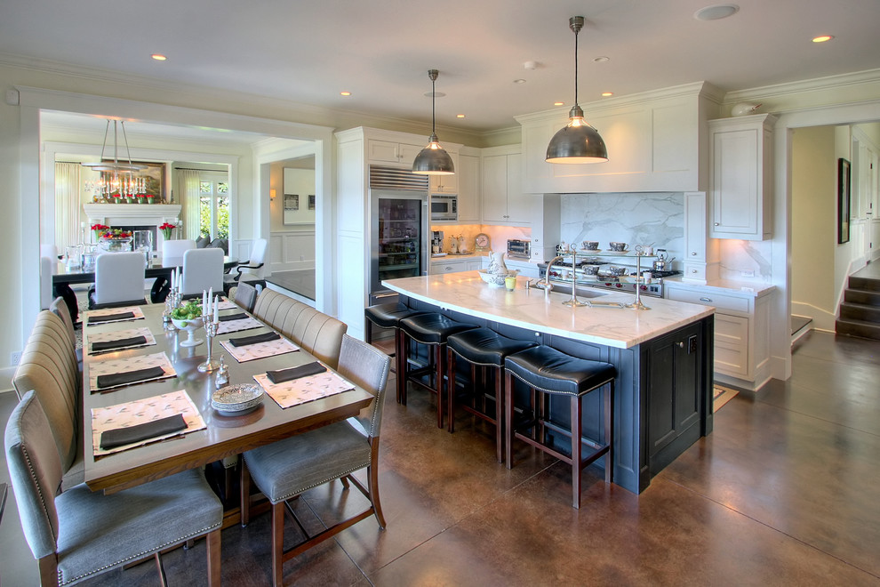 This is an example of an expansive traditional eat-in kitchen in Seattle with black cabinets, marble benchtops, stainless steel appliances, concrete floors and with island.