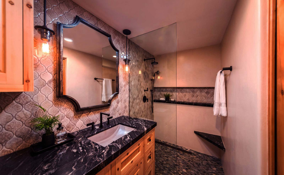 На фото: ванная комната в стиле модернизм с душем без бортиков, унитазом-моноблоком, бежевой плиткой, керамогранитной плиткой, бежевыми стенами, врезной раковиной, открытым душем, черной столешницей и встроенной тумбой