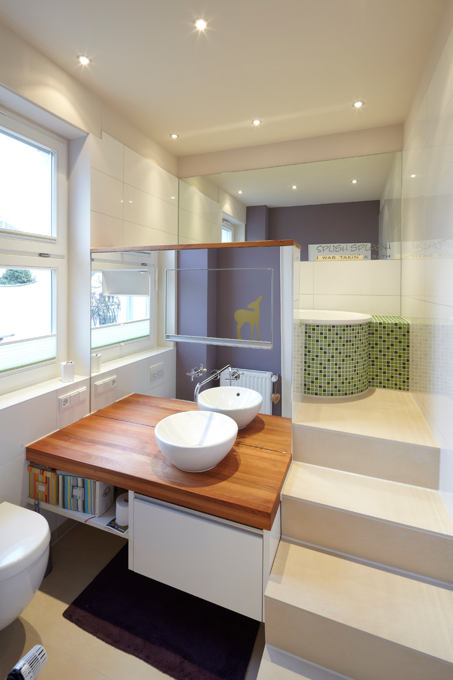 Photo of a mid-sized contemporary master bathroom in Essen with wood benchtops, a drop-in tub, white tile, green tile, purple walls, white cabinets, mosaic tile and a vessel sink.